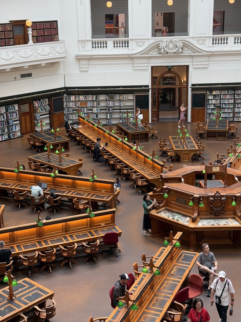 A circular reading room with wooden desks and bookshelves