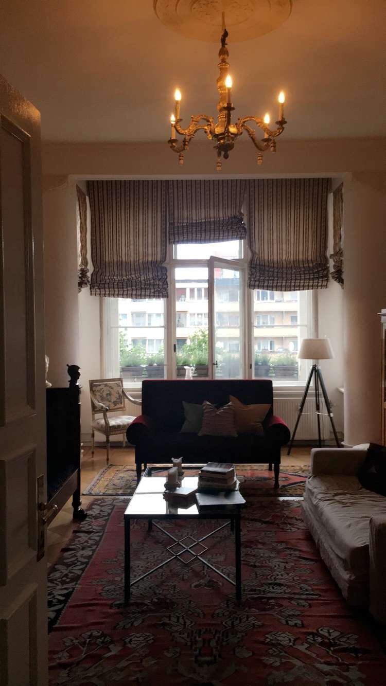 A softly lit interior with a chandelier and tall windows