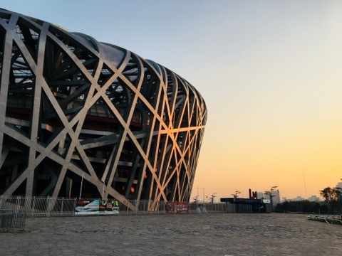 A stadium with an interwoven exterior at sunset