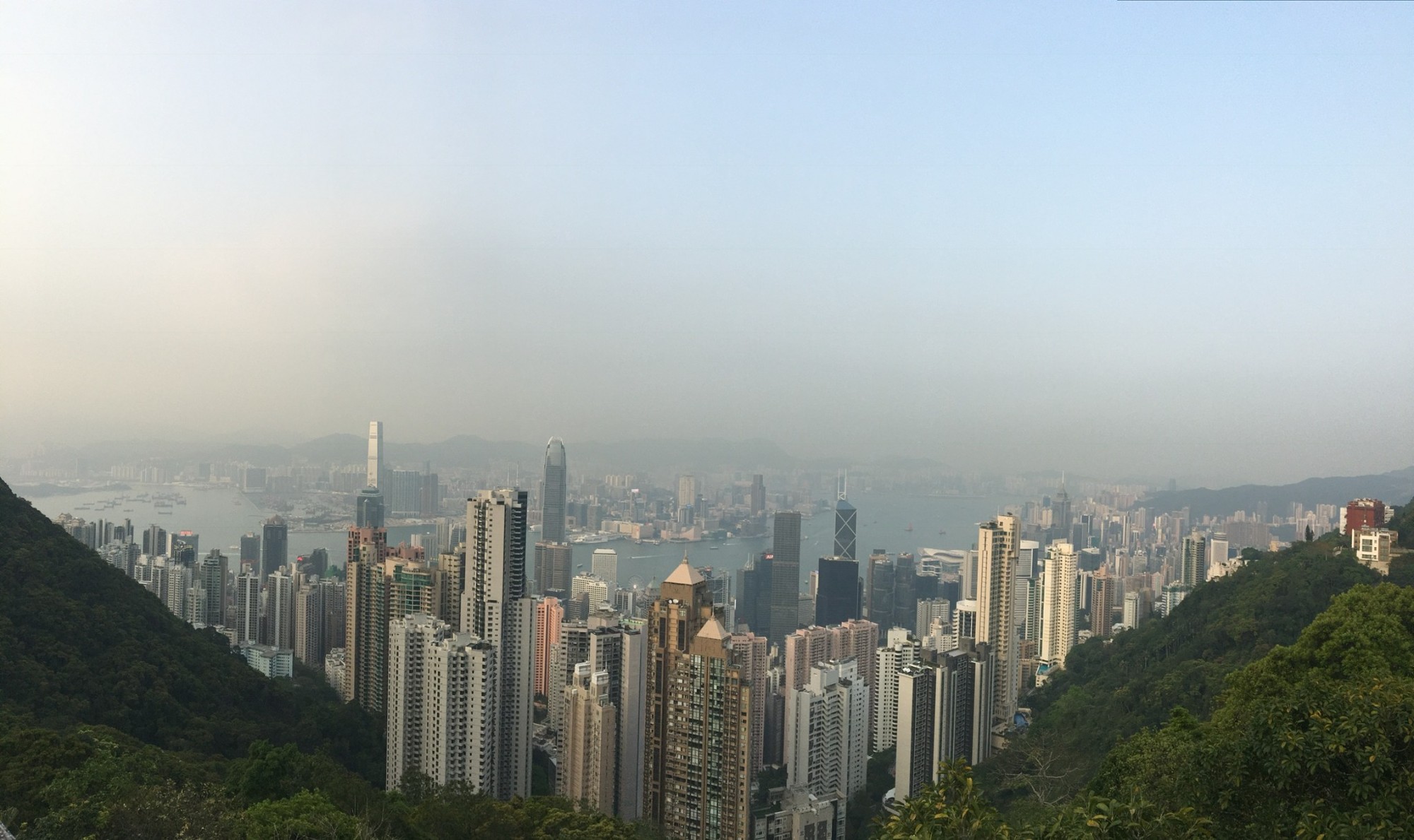 A dense city skyline surrounded by green hills