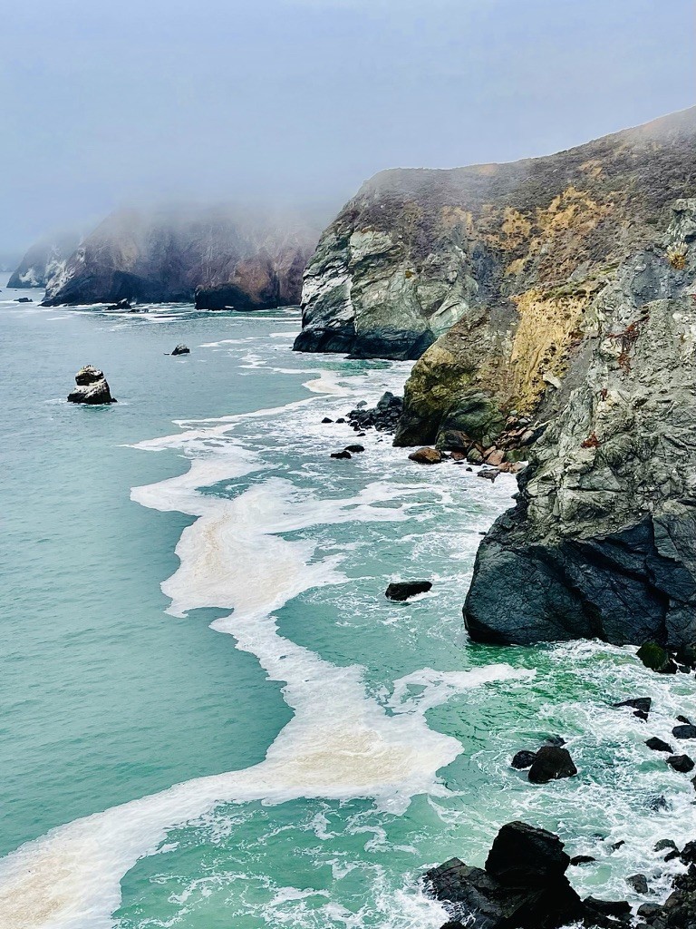 Waves breaking along a rugged coast in the mist