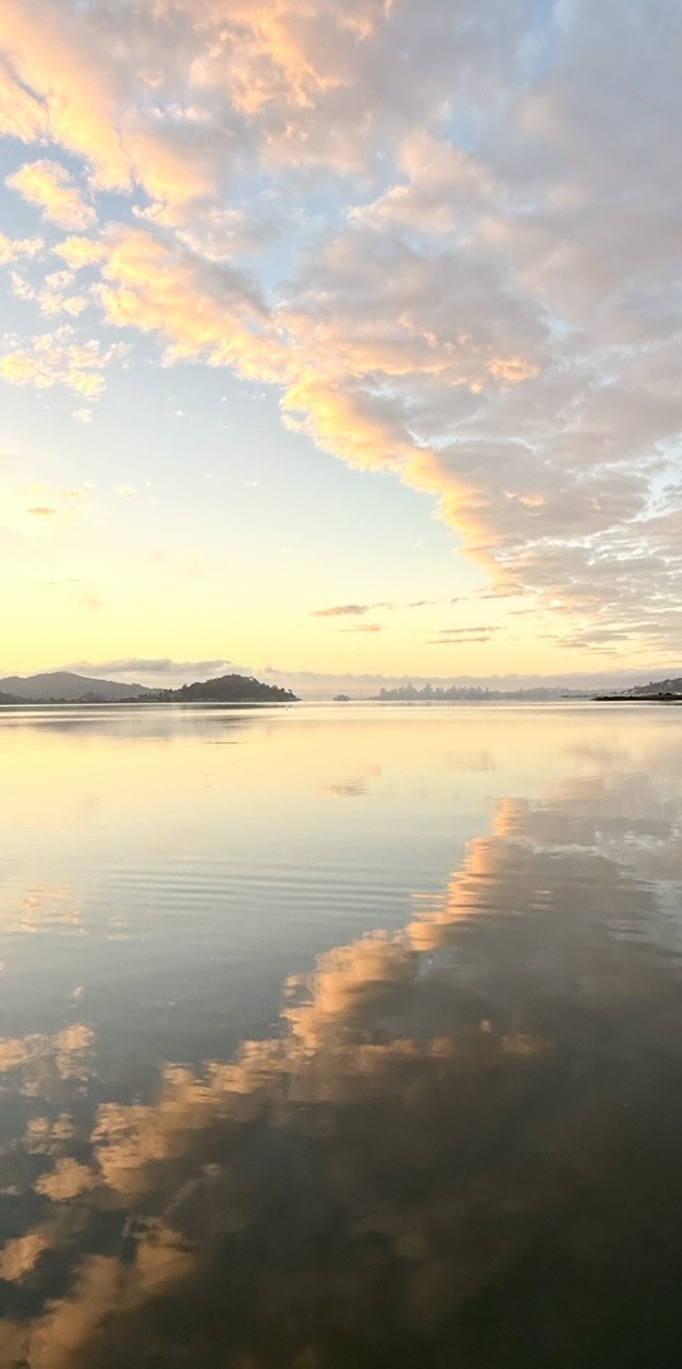 Sunset clouds reflected in calm shallow water